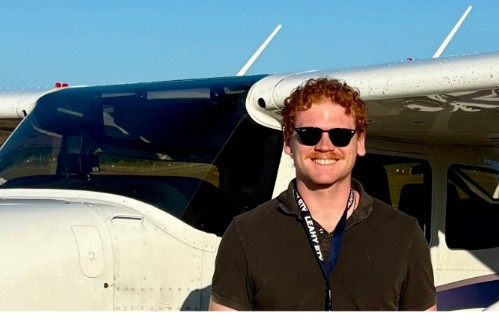 Jack ZuWallack standing in front of the training airplane